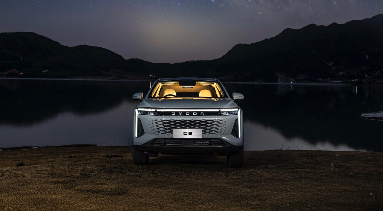 Omoda C9 front view by a lake at dusk